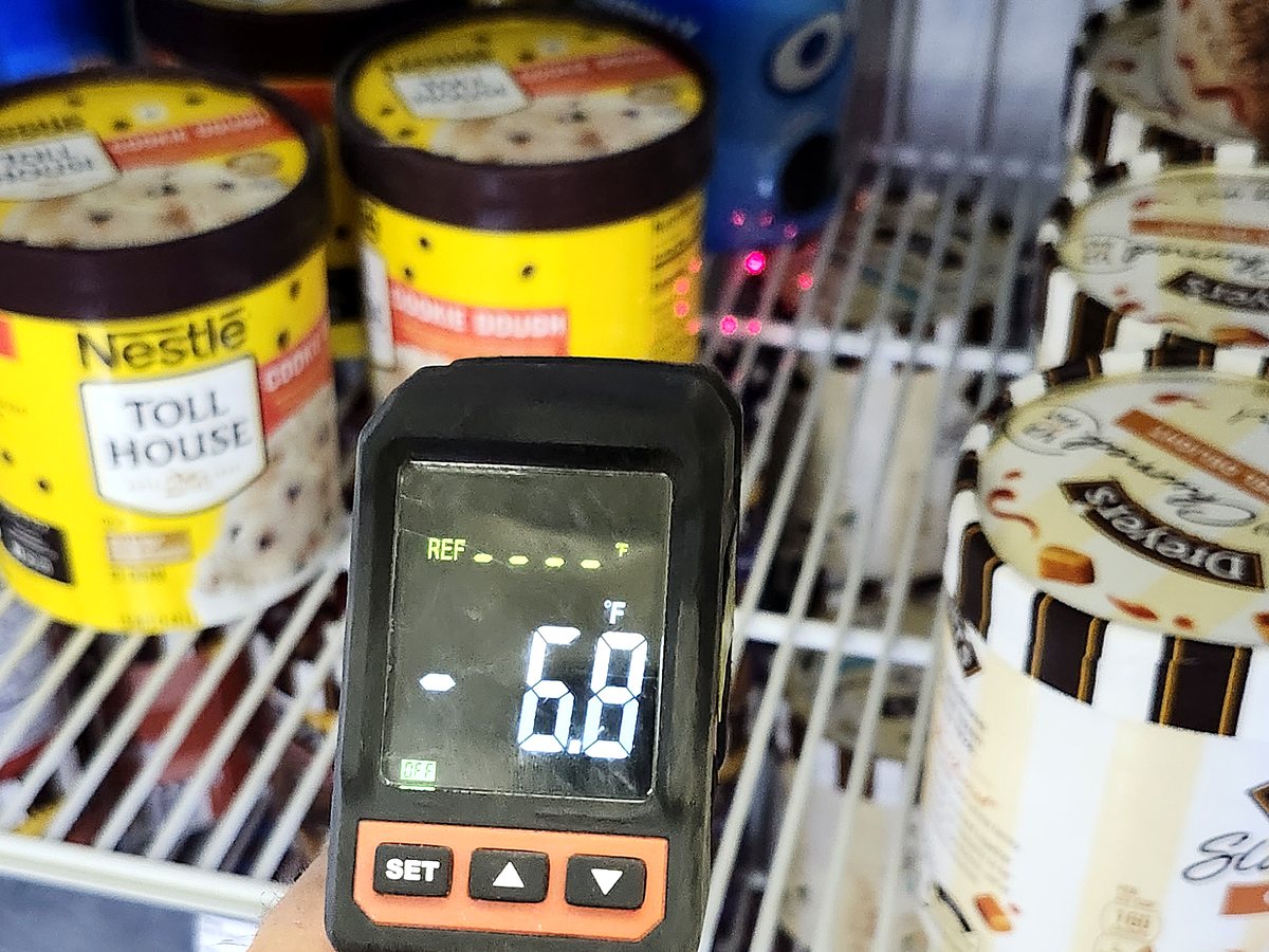 Checking freezer temperature in a commercial ice cream case
