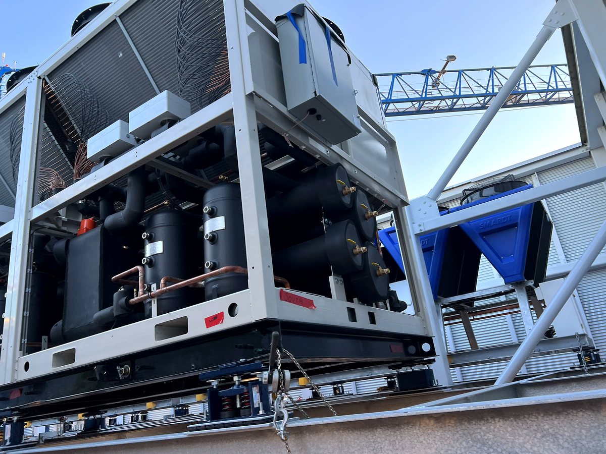 Air-cooled chiller being craned into place on a commercial job